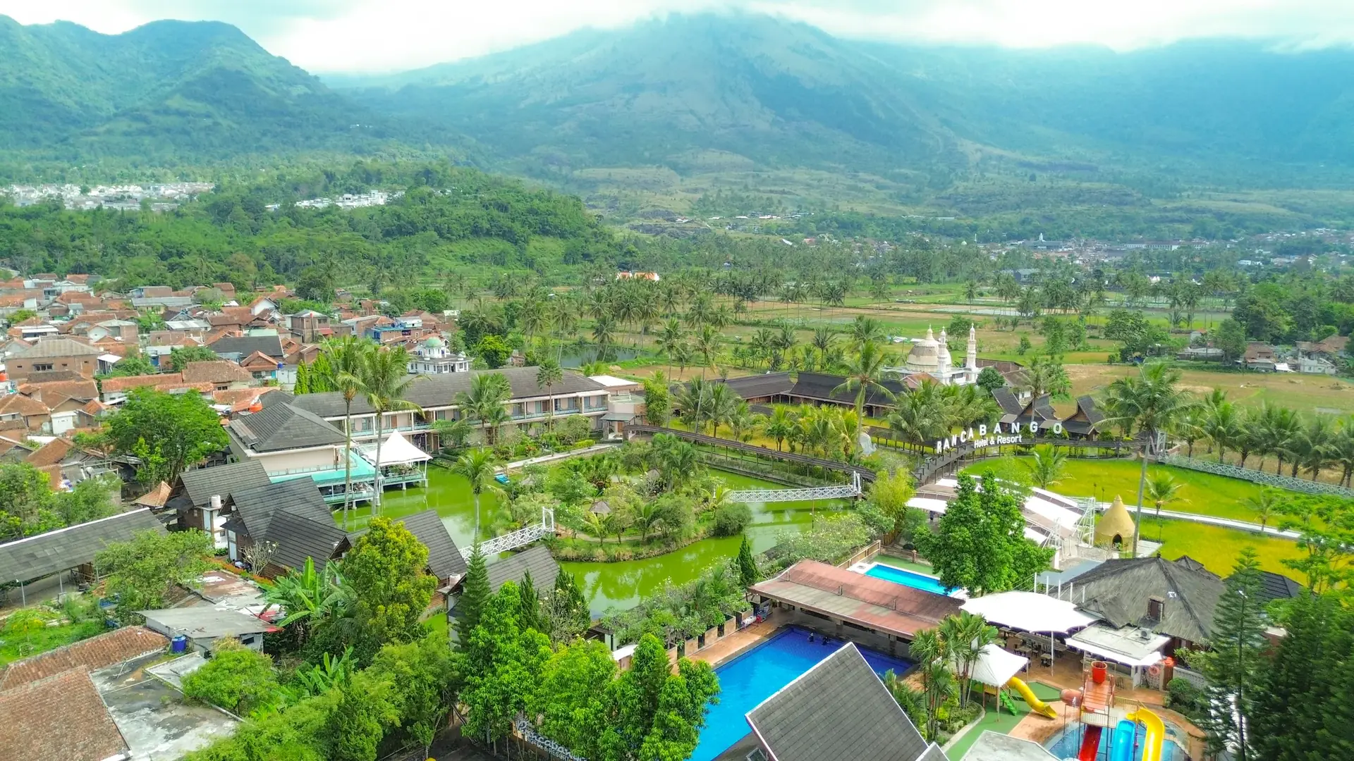 Panorama sawah, danau, dan barisan gunung mengelilingi Rancabango